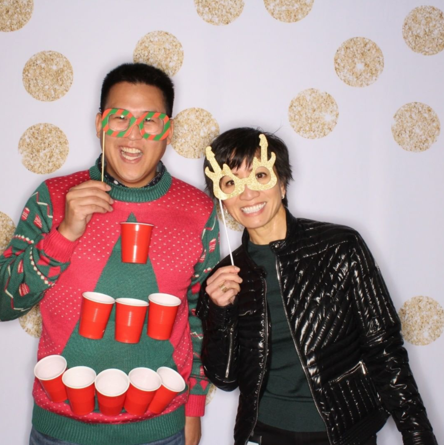 A couple taking a selfie wearing festive clothing in the photo booth