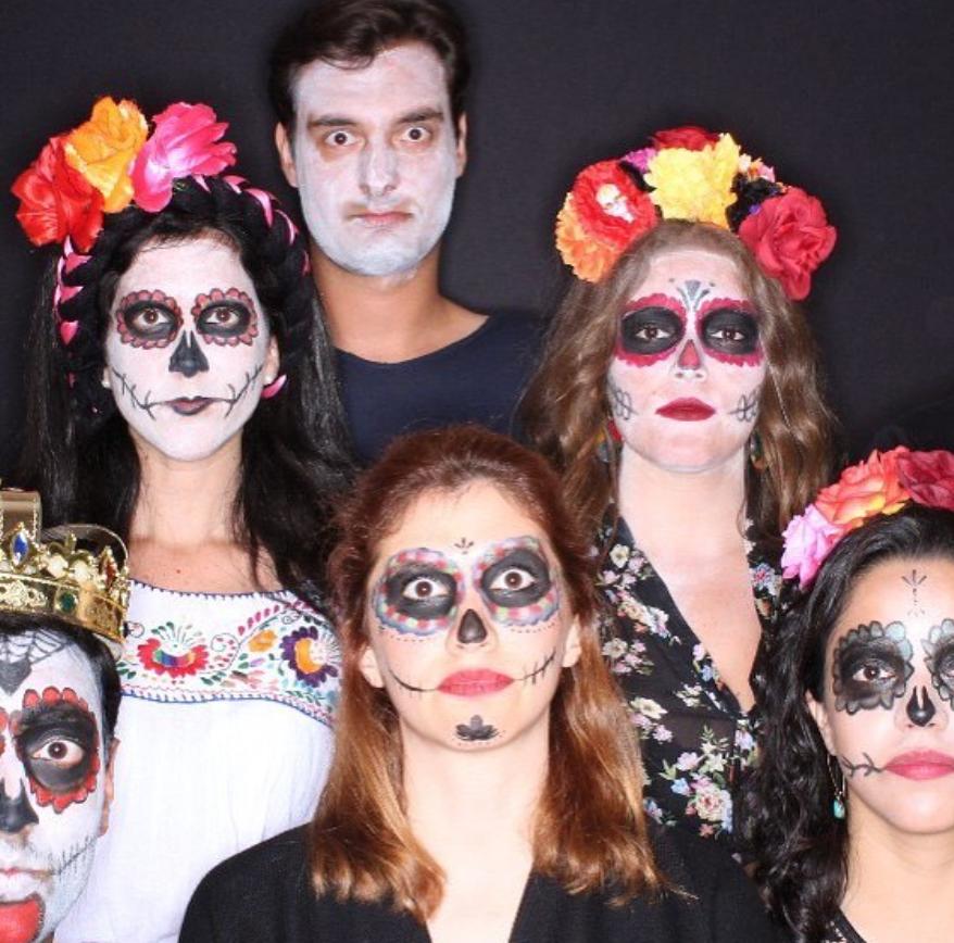 A family wearing a dia de los muertos constume taking a picture in the photo booth